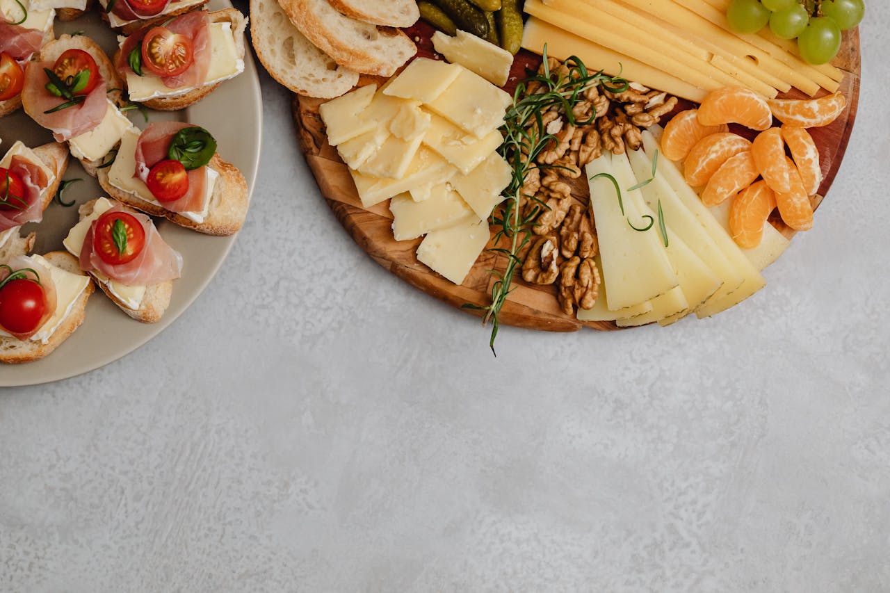 Delicious cheese and charcuterie board with fruits, nuts, and canapés on a light background.